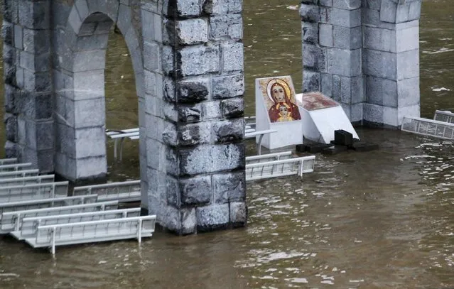 The sanctuary of Lourdes flooded, in Lourdes, southwestern France, Tuesday, June 18, 2013. French rescue services and police are evacuating hundreds of pilgrims from hotels threatened by floodwaters from a rain-swollen river in the Roman Catholic shrine town of Lourdes. (Photo by Bob Edme/AP Photo)
