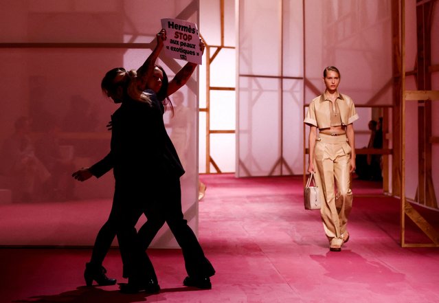 A protester holds a placard reading “Hermes stop exotic skin” as a model presents a creation by designer Nadege Vanhee-Cybulski as part of her Spring/Summer 2025 Women's ready-to-wear collection show for fashion house Hermes during Paris Fashion Week in Paris, France on September 28, 2024. (Photo by Johanna Geron/Reuters)