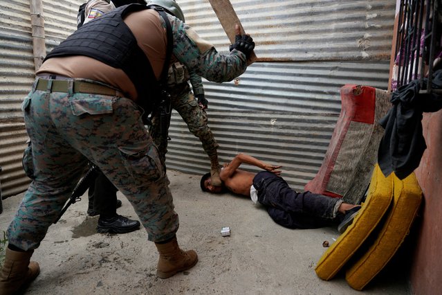 A man who was found smoking marijuana is beaten outside of his house with a piece of wood by an Ecuadorean soldier during a joint police and military security operation in a low-income neighborhood on the outskirts of Guayaquil, in Duran, Ecuador on October 16, 2024. (Photo by Santiago Arcos/Reuters)
