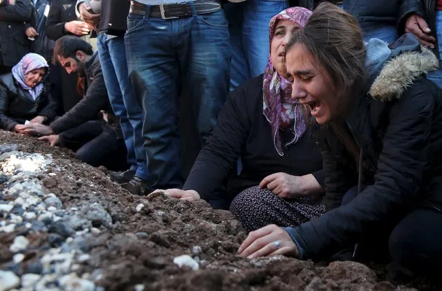 Relatives of Siyar Salman mourn over his grave during a funeral ceremony in the Kurdish dominated southeastern city of Diyarbakir, Turkey, December 15, 2015. According to local media, Salman, a 19-year old man, was killed on Monday in Diyarbakir during a protest against the curfew in Sur district. (Photo by Sertac Kayar/Reuters)