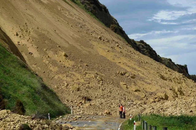Emergency services officers inspect the damage caused to Rotherham Road near Waiau town, some 90 kms to the south of Kaikoura, on November 16, 2016, after an earthquake hit New Zealand just after midnight on Monday. Rescue efforts after a devastating earthquake in New Zealand intensified on November 16 as a fleet of international warships began arriving in the disaster zone. (Photo by Matias Delacroix/AFP Photo)