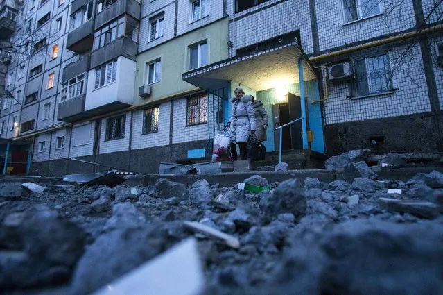 People walk out of a building near damaged pavement following a shelling, according to locals, in Donetsk February 4, 2015. (Photo by Maxim Shemetov/Reuters)