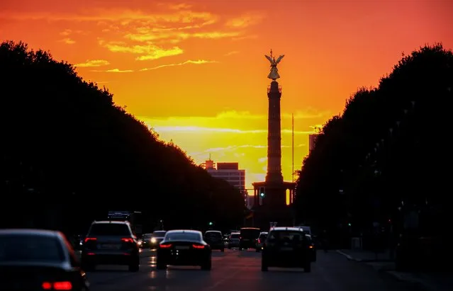 In this October 4, 2016 photo he sun sets behind the Victory Column, a major landmark of Berlin, Germany. (Photo by Kay Nietfeld/DPA via AP Photo)