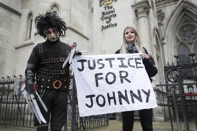 Johnny Depp supporters hold a banner outside the High Court in London, Thursday, March 18, 2021. Johnny Depp's bid to overturn a damning ruling that he assaulted his ex-wife Amber Heard and put her in fear for her life will be considered by the Court of Appeal on Thursday. (Photo by Kirsty Wigglesworth/AP Photo)