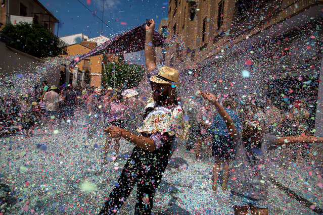 People are showered with confetti during the traditional procession of “alfabegues” (basil plants) as part of the patron saint festivities in the village of Betera, eastern Spain, 15 August 2018. The plants are carried to church under a shower of confetti. The tradition has been held for more than 400 years. (Photo by Biel Alino/EPA/EFE)