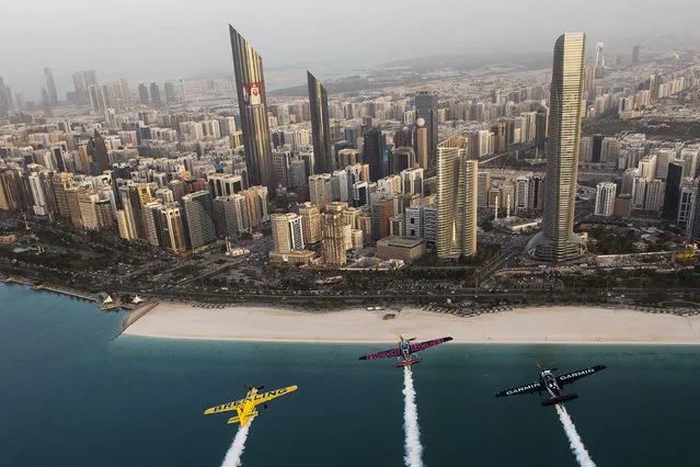 In this Tuesday, February 10, 2015, photo provided by Joerg Mitter via Global-Newsroom, Francois Le Vot of France, from left, U.S. Kirby Chambliss and Pete McLeod of Canada fly over waters off Abu Dhabi, the United Arab Emirates. (Photo by Predrag Vuckovic/AP Photo/Global-Newsroom)