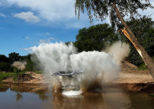 Carlos Sainz of Spain drives his Peugeot through the water as his car's hood comes up during the Buenos Aires-Rosario prologue stage of Dakar Rally 2016 in Arrecifes, Argentina, January 2, 2016. (Photo by Marcos Brindicci/Reuters)