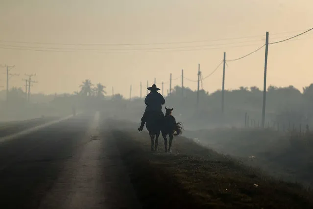A man rides horseback along a road near Colon, Cuba, November 30, 2016. (Photo by Ivan Alvarado/Reuters)