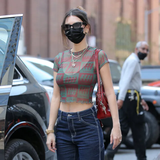 American model and actress Emily Ratajkowski is seen in a sheer Inamorata top with black bra, jeans, red handbag and gold watch in New York City on April 20, 2021. Emily valets her car with her dog Colombo. (Photo by Christopher Peterson/Splash News and Pictures)