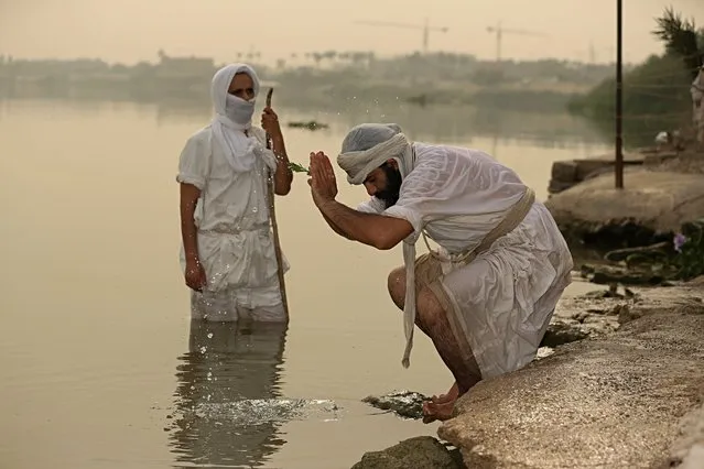 In this Sunday, October 14, 2018 photo, followers of the ancient Mandaean religious sect perform their rituals along a strip of embankment on the Tigris River reserved for them, in Baghdad, Iraq. Mandaeanism follows the teachings of John the Baptist, a saint in both the Christian and Islamic traditions, and their rituals revolve around water. Iraq’s soaring water pollution is threatening the religious rites of the tight-knit community, already devastated by 15 years of war. (Photo by Hadi Mizban/AP Photo)