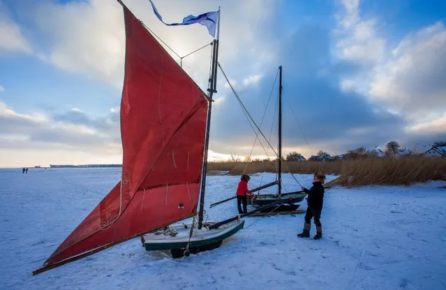 Fritz Peters (R) prepares his ice glider “Storm Gull”, which he built twelve years ago from historic construction plans, for a ride on the ice of the Saaler Bodden lagoon near Ahrenshoop, Germany, 21 January 2016. Sub-zero temperatures in the past days have created a thick layer of ice and made it possible for the first time since 2009 to sail the unique vehicles on the frozen flat. Some 20 of the historic ice gliders – which in former times were mainly used to transport goods and feed – are expected to gather here over the weekend for the regional “Ice Festival”. (Photo by Jens Buettner/EPA)