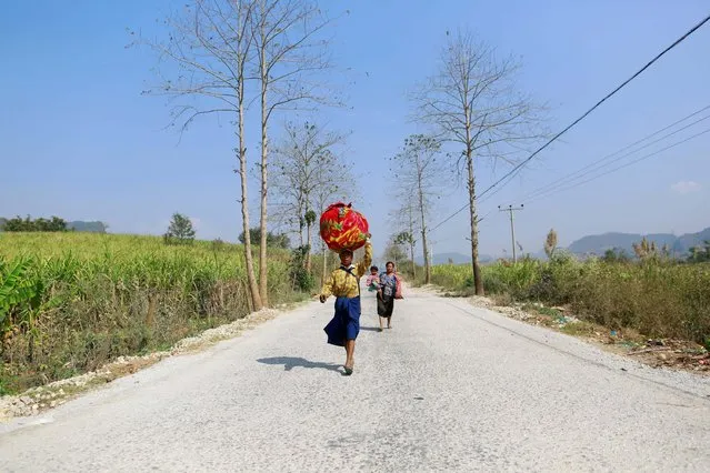 A family displaced by recent violence, walks down a road, in Laukkai February 17, 2015. (Photo by Soe Zeya Tun/Reuters)