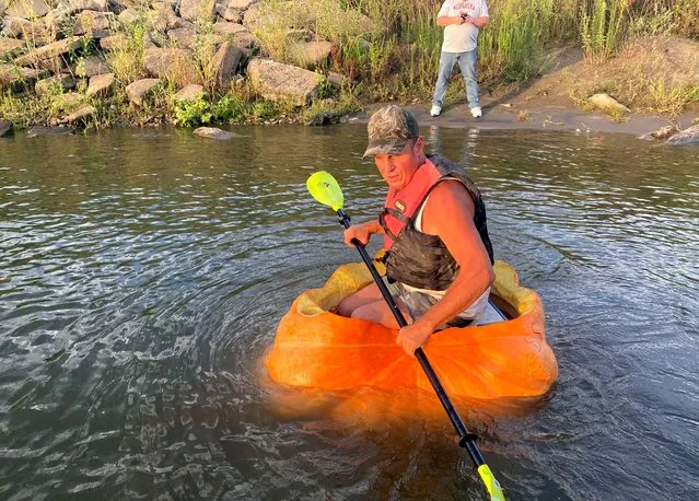 A man floats down the Missouri river in a giant hollowed out pumpkin, in Bellevue, Nebraska, U.S., August 27, 2022, in this picture obtained from social media. (Photo by Phil Davidson/City Of Bellevue via Reuters)