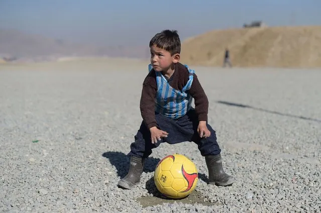 Afghan boy five-year-old Murtaza Ahmadi, a young Lionel Messi fan, plays football in Kabul on February 1, 2016. Barcelona star Lionel Messi is hoping to arrange a meeting with an Afghan boy who shot to fame after pictures of him dressed in a striped plastic bag jersey went viral, Kabul's football federation said on February 1. (Photo by Shah Marai/AFP Photo)