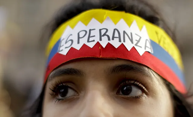 A Venezuelan anti-government protester wears a headband with the colors of the Venezuelan flag and the word “Hope” in Spanish, during a demonstration in Buenos Aires, Argentina, Wednesday, January 23, 2019. Hundreds of people, mostly Venezuelan migrants, held a rally against Venezuelan President Nicolas Maduro and in favor of Juan Guaido, head of Venezuela's opposition-run congress who today proclaimed himself president of the South American nation. (Photo by Natacha Pisarenko/AP Photo)