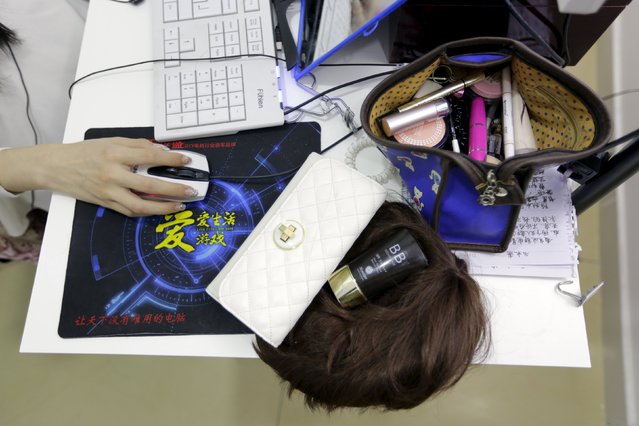 Online hostess Sun Xiaohou uses a computer mouse, next to her wig and cosmetic bag, as she gives a live broadcast in Beijing April 4, 2015. (Photo by Jason Lee/Reuters)