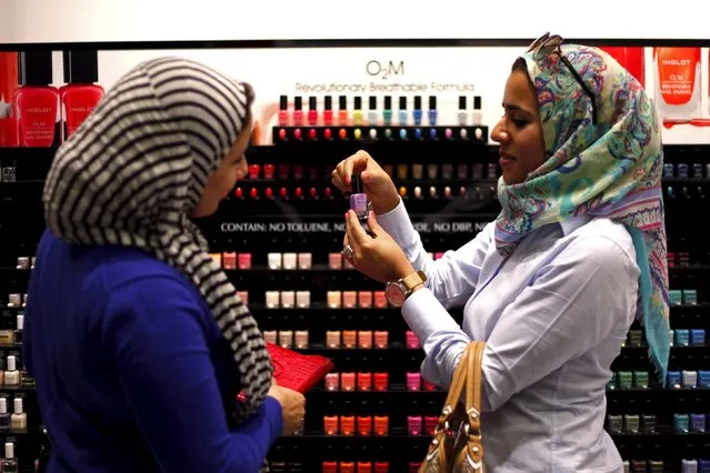 Two Egyptian women buy “breathable” nail polish from a store in a Dubai shopping mall in this November 18, 2013 file photo. The United Arab Emirates is expected to report inflation data this week. (Photo by Ahmed Jadallah/Reuters)