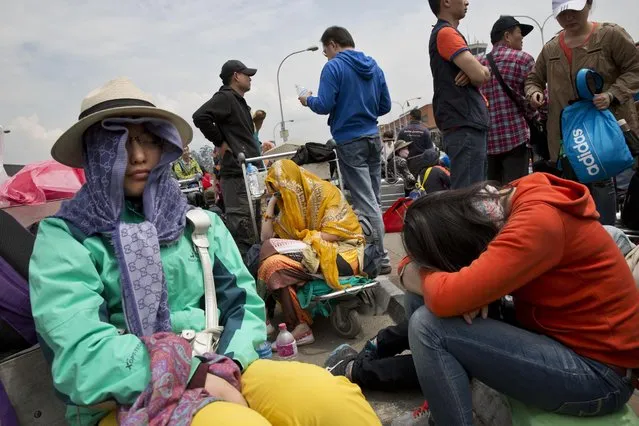 Chinese nationals gather outside the Kathmandu international airport, Sunday, April 26, 2015. (Photo by Bernat Armangue/AP Photo)