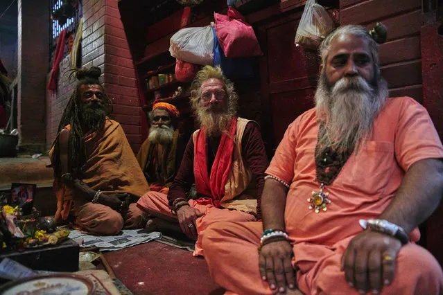 Four holy men sit in a building, taken in Kathmandu, Nepal. Wandering through the cities and forests of Nepal are the holy men, or Sadhus, who have left all materialistic pleasures behind to live a life devoted to God. Their appearances vary from brightly coloured face paints, and decorations, to minimalistic practical clothing, but they all represent the fundamental values and meanings of Hinduism. Danish photographer Jan Moeller Hansen visited the ancient capital city of Kathmandu between 2013 and 2016 and documented the mysterious holy wanderers. (Photo by Jan Moeller Hansen/Barcroft Images)