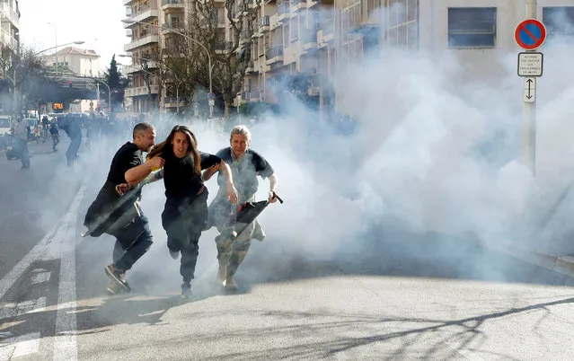 Protesters run away as tear gas is fired during 19th round of “yellow vests” protests in Nice, France, March 23, 2019. (Photo by Eric Gaillard/Reuters)