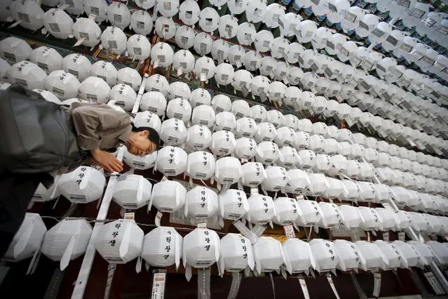 A woman prays under lotus lanterns that have been tagged with prayer petitions and names, in preparation for the upcoming birthday of Buddha at Jogye temple in Seoul, South Korea, April 30, 2015. Buddha's birthday is celebrated on May 25 in South Korea. (Photo by Kim Hong-Ji/Reuters)
