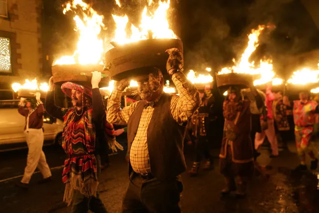 Men, known as guisers, carry burning whisky barrels through the streets during the Allendale Tar Barrels Parade in the UK on Monday, January 1, 2024. (Photo by Owen Humphreys/PA Images via Getty Images)