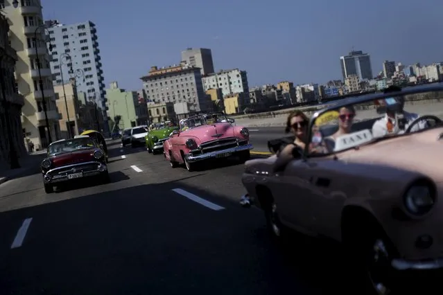 Tourists ride in a vintage car at the “Malecon” seafront in Havana, March 16, 2016. (Photo by Ueslei Marcelino/Reuters)