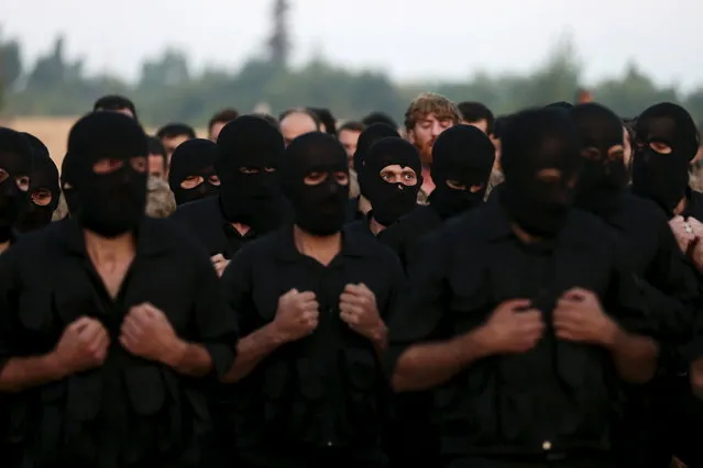 Rebel fighters take part in a military display as part of a graduation ceremony at a camp in eastern al-Ghouta, near Damascus, Syria July 12, 2015. The newly graduated rebel fighters, who went through military training, will join the the Free Syrian Army's Al Rahman legion. (Photo by Bassam Khabieh/Reuters)