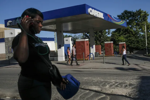 People walk past a closed gas station in Port-au-Prince, Haiti, Thursday, November 11, 2021. (Photo by Matias Delacroix/AP Photo)