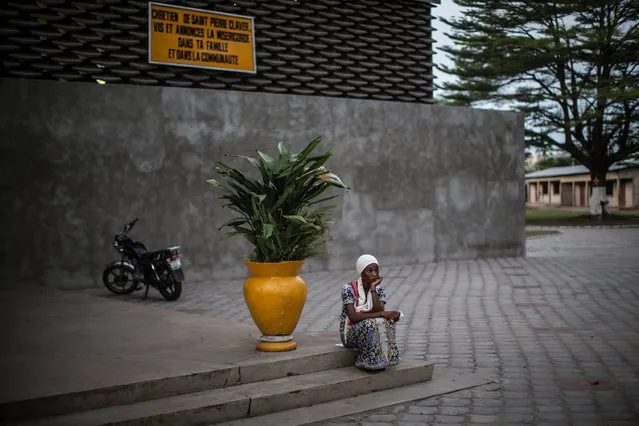 A woman resident of the Bacongo district in Brazzaville sits on the stairs of the Saint Pierre Claver church on March 26, 2016 for the beginning of the Easter vigil. (Photo by Marco Longari/AFP Photo)