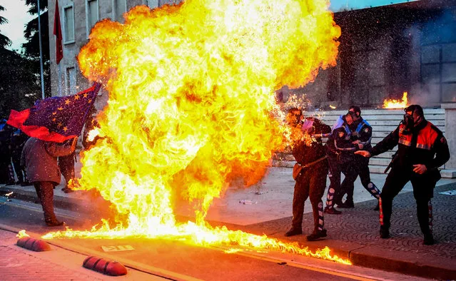 Albanian policemen try to avoid the flames from a petrol bomb during an anti-government protest called by the opposition on May 11, 2019 in Tirana. (Photo by Gent Shkullaku/AFP Photo)