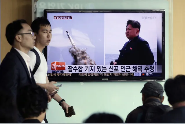 South Korean men pass by a TV news program showing images published in North Korea's Rodong Sinmun newspaper of North Korea's ballistic missile believed to have been launched from underwater and North Korean leader Kim Jong-un, at Seoul Railway station in Seoul, South Korea, Saturday, May 9, 2015. (Photo by Ahn Young-oon/AP Photo)