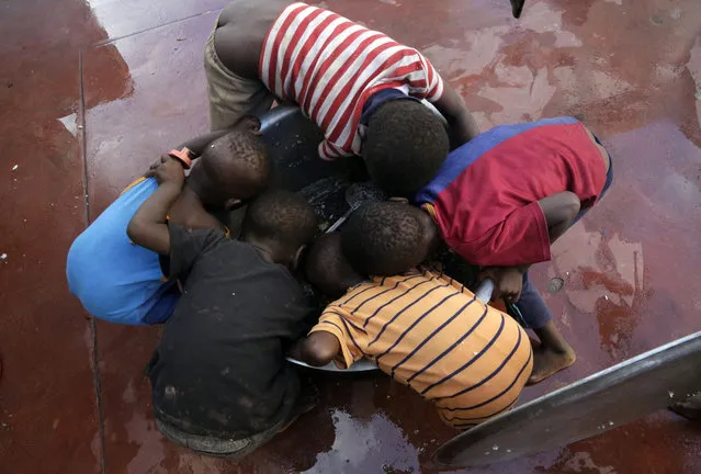 Kids scrape for remaining rice inside a pot at a displacement center in Beira, Mozambique, Friday, March 22, 2019. A week after Cyclone Idai hit coastal Mozambique and swept across the country to Zimbabwe, its death, destruction and flooding continues to grow in southern Africa, making it one of the most destructive natural disasters in the region's recent history. (Photo by Themba Hadebe/AP Photo)