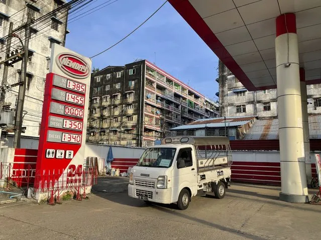 A vehicle is driven near a signboard with fuel prices at a gas station in Botahtaung township in Yangon, Myanmar on November 12, 2021. (Photo by AP Photo/Stringer)