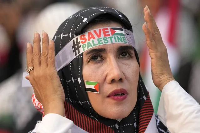 A protester adjusts her headband during a rally and prayer in support of the Palestinians in Gaza, in Jakarta, Indonesia, Sunday, April 7, 2024. (Photo by Dita Alangkara/AP Photo)