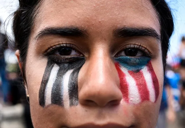 Demonstrator poses for a picture with her face painted during the national strike calling for the resignation of Governor Ricardo Rossello in San Juan, Puerto Rico on July 22, 2019. Puerto Rico's embattled governor Ricardo Rossello announced his resignation late Wednesday, July 24, 2019, following two weeks of massive protests triggered by the release of a chat exchange in which he and others mocked gays, women and hurricane victims. “I announce that I will be resigning from the governor's post effective Friday, August 2 at 5 pm”, Rico said, in a video broadcast by the government. (Photo by Gabriella N. Baez/Reuters)