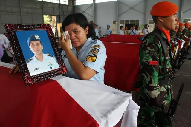 A relative of military personnel grieves during a send-off ceremony at the military airbase in Medan on July 1, 2015, a day after an Indonesian Air Force C-130 Hercules plane crashed into a residential area of the city shortly after takeoff. (Photo by AFP Photo/ATAR)