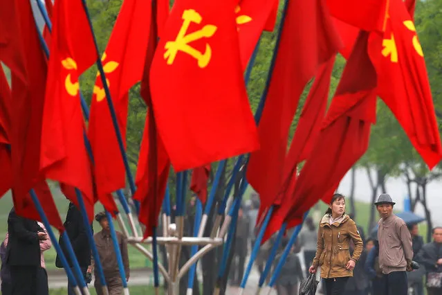 People walk behind party flags placed near April 25 House of Culture, the venue of Workers' Party of Korea (WPK) congress in Pyongyang, North Korea May 6, 2016. (Photo by Damir Sagolj/Reuters)