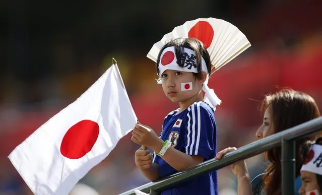 A Japan fan holds flags before a FIFA Women's World Cup soccer tournament semifinal between Japan and England in Edmonton, Alberta, Canada, on Wednesday, July 1, 2015. (Photo by Jeff McIntosh/The Canadian Press via AP Photo)