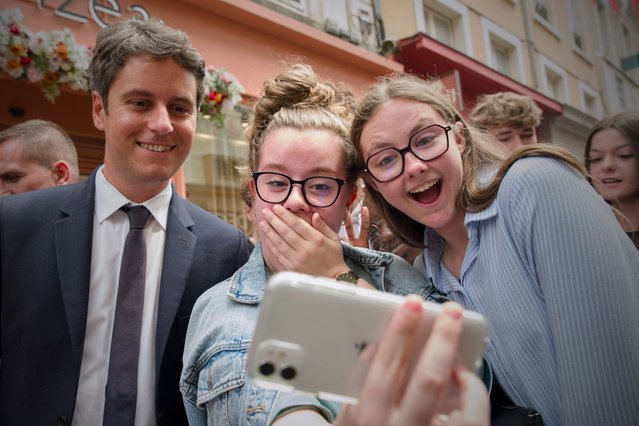 France's Prime Minister Gabriel Attal (C) poses for a selfie with young people during a campaign visit in Le Mans, northwestern France on June 20, 2024, ahead of the upcoming parliament elections. (Photo by Guillaume Souvant/AFP Photo)
