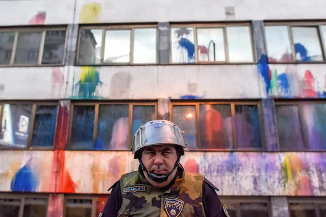 A Macedonian police officer guards the Public Revenue Office building, spray  painted by protestors with water guns filled with paint, during the protest dubbed “Colorful  Revolution” against Macedonian President Ivanov's decision on wiretapping amnesty, in Skopje, The Former Yogoslav Republic of Macedonia, 10 May 2016. Protests in Macedonia continue daily for almost three weeks, after the decision of the president George Ivanov  to pardon dozens of politicians who were involved in wiretapping scandal. (Photo by Georgi Licovski/EPA)