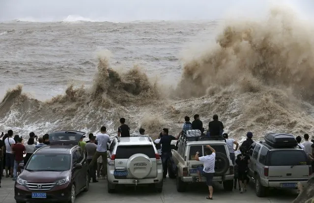 People look on as waves, under the influence of Typhoon Chan-hom, hit the shore in Wenling, Zhejiang province, China, July 10, 2015. More than 865,000 people have been evacuated from China's eastern province of Zhejiang ahead of Saturday's expected landfall of Typhoon Chan-Hom, state news agency Xinhua said. (Photo by William Hong/Reuters)