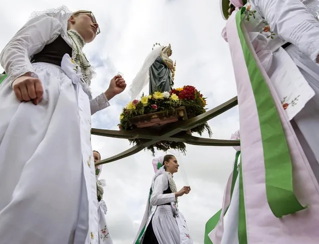 Believers dressed in the traditional clothes of the Sorbs carry the statue  of Virgin Mary during a procession near Rosenthal, eastern Germany, Monday, May 16, 2016. Traditionally on Whit Monday catholic faithful Sorbs, a Slavic minority near the German-Polish border, celebrate an open air mass in the small village east of Dresden. (Photo by Jens Meyer/AP Photo)