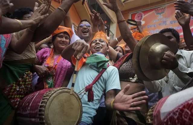 Bharatiya Janata Party (BJP) supporters celebrate the party's winning preliminary result outside their office in Gauhati, India, Friday, May 16, 2014. India's opposition leader Narendra Modi and his party won national elections in a landslide Friday, preliminary results showed, driving the long-dominant Congress party out of power in the most commanding victory India has seen in more than a quarter century. (Photo by Anupam Nath/AP Photo)