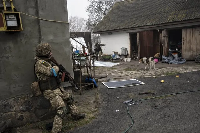 Ukrainian soldiers operate inside an abandoned house during a military sweep to search for possible remnants of Russian troops after their withdrawal from villages in the outskirts of Kyiv, Ukraine, Friday, April 1, 2022. (Photo by Rodrigo Abd/AP Photo)