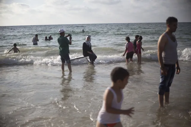 Palestinians, many of whom came from the West Bank, bathe in the Mediterranean Sea during the last day of the Eid al-Fitr holiday as the sun sets in Tel Aviv, Israel, Sunday, July 19, 2015. (Photo by Ariel Schalit/AP Photo)