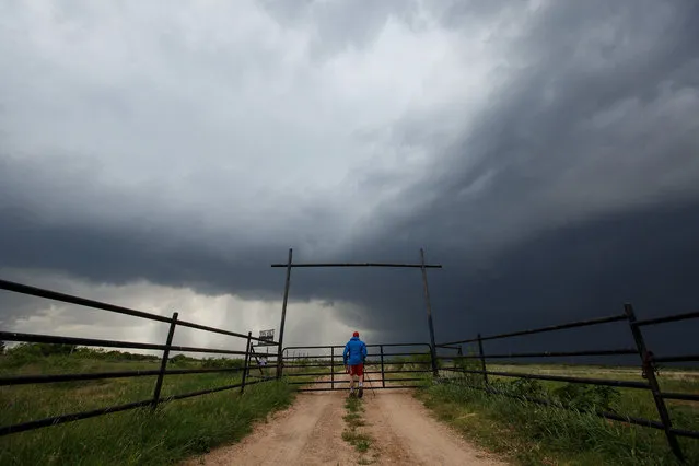 Center for Severe Weather Research intern Hunter Anderson takes photographs of a supercell thunderstorm, May 10, 2017 in Quanah, Texas. (Photo by Drew Angerer/Getty Images)