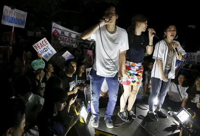 Students shout slogans during a rally denouncing Japan's Prime Minister Shinzo Abe's administration outside parliament in Tokyo July 24, 2015. Abe pushed through parliament's lower house legislation that could see troops sent to fight abroad for the first time since World War Two, despite protests and a risk of further damage to his sagging ratings. (Photo by Thomas Peter/Reuters)