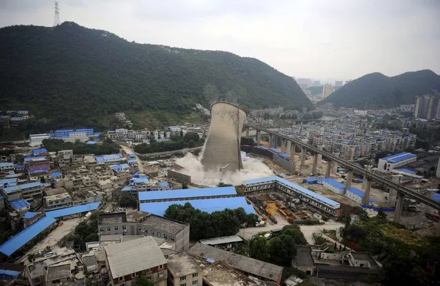 A cooling tower of a coal-burning power plant topples during a controlled demolition in Guiyang, Guizhou province, China, July 22, 2015. (Photo by Reuters/Stringer)