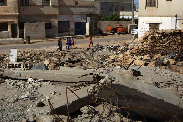 Boys walk near rubble in the rebel held town of Nasib, Deraa countryside, Syria, May 30, 2016. (Photo by Alaa Al-Faqir/Reuters)